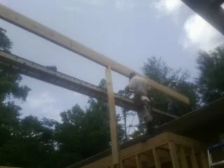 Carpenter setting a ridge beam over a new addition frame — Ice Dam Removal by Roofing Brothers in San Bernardino