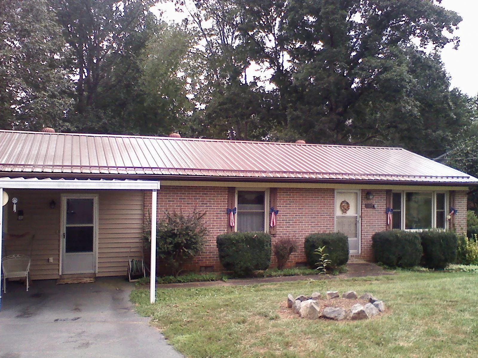 Bronze metal roof and carport on a brick ranch home — Roof Repair work by our crew in San Bernardino